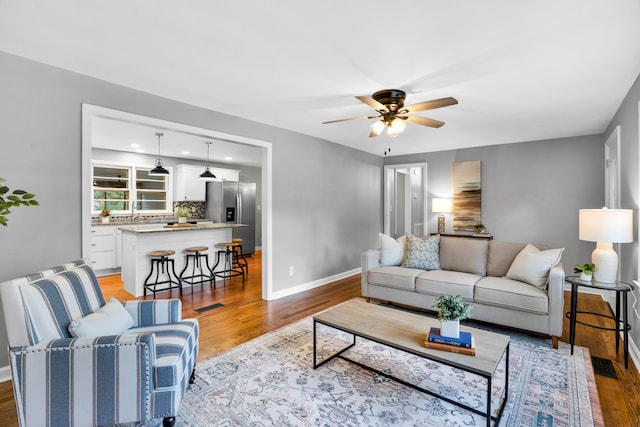 living room featuring ceiling fan and light hardwood / wood-style floors