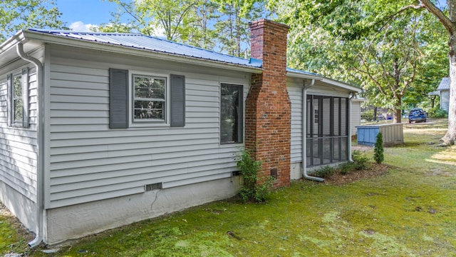 view of side of property with a lawn and a sunroom