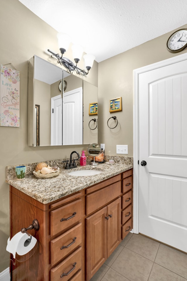 bathroom featuring tile patterned flooring, a textured ceiling, and vanity