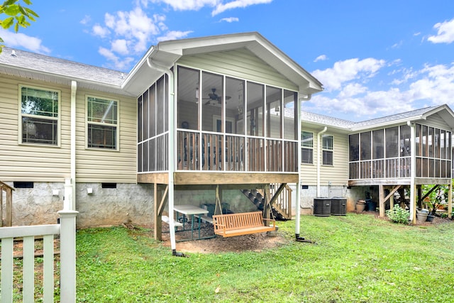 rear view of property featuring a lawn, central air condition unit, and a sunroom