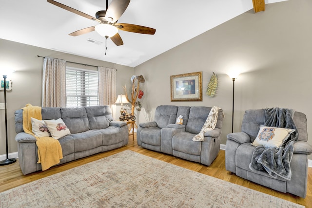 living room with light wood-type flooring, lofted ceiling with beams, and ceiling fan