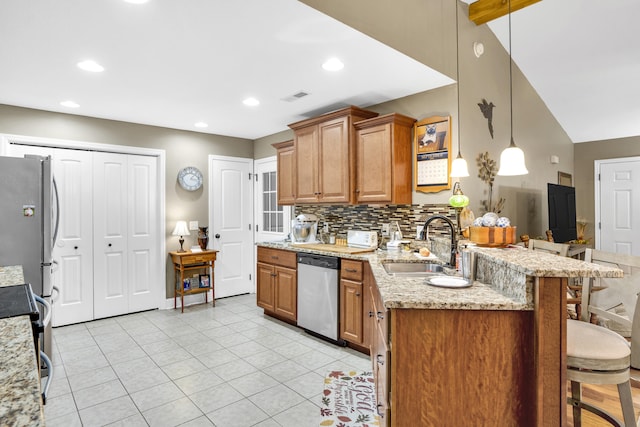 kitchen with stainless steel appliances, a kitchen breakfast bar, light stone counters, kitchen peninsula, and pendant lighting