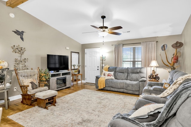 living room with ceiling fan, light hardwood / wood-style flooring, and lofted ceiling with beams