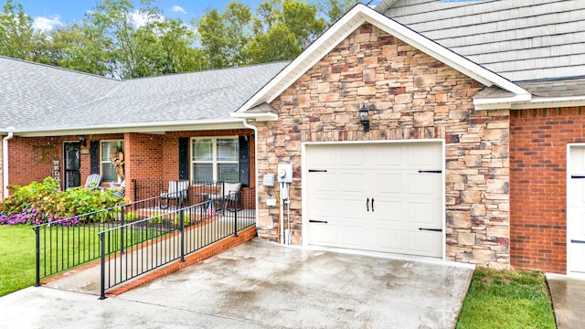 view of front of home with a garage, covered porch, and a front yard