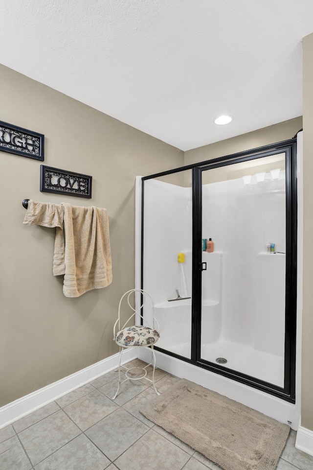 bathroom with tile patterned floors and an enclosed shower