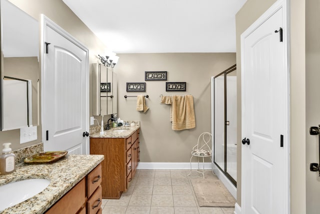 bathroom with a shower with door, vanity, and tile patterned flooring