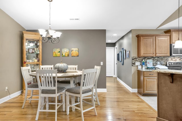 dining room with a notable chandelier and light hardwood / wood-style flooring