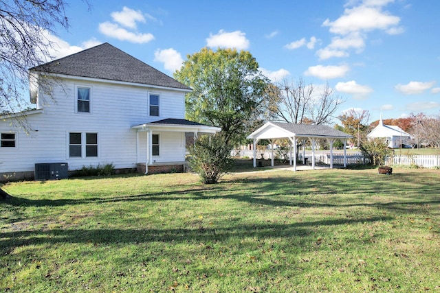 back of property featuring a gazebo, a yard, and central AC