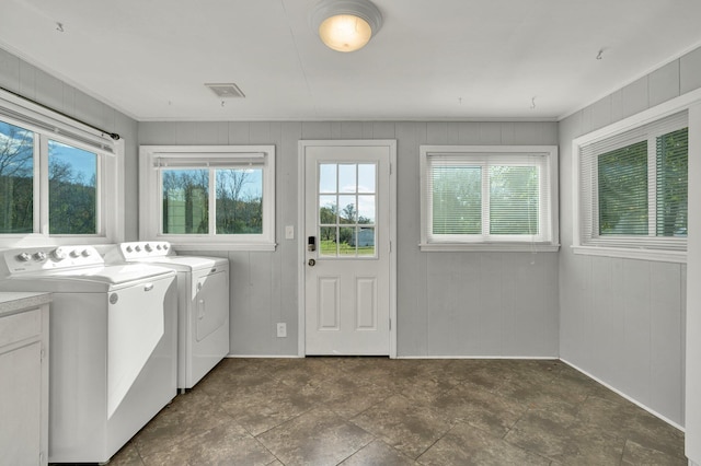 laundry room featuring wooden walls and washing machine and clothes dryer