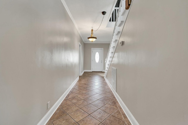 doorway to outside with crown molding and light tile patterned floors