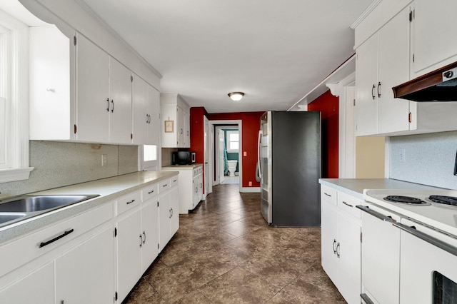 kitchen featuring electric range, white cabinetry, and stainless steel refrigerator