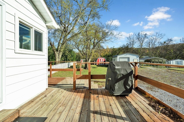 deck with grilling area and a storage shed