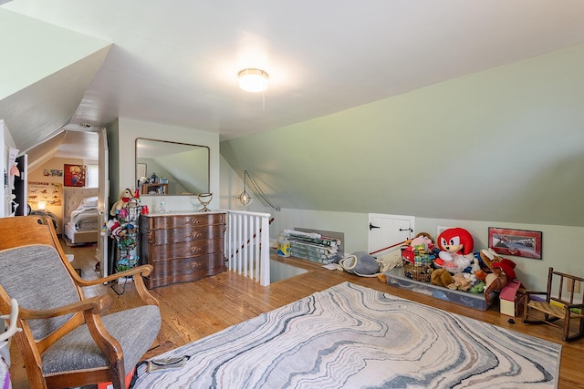 bedroom featuring wood finished floors and lofted ceiling