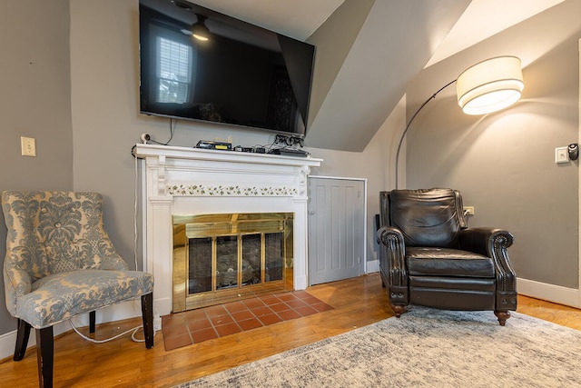 sitting room featuring wood finished floors, a fireplace, and baseboards