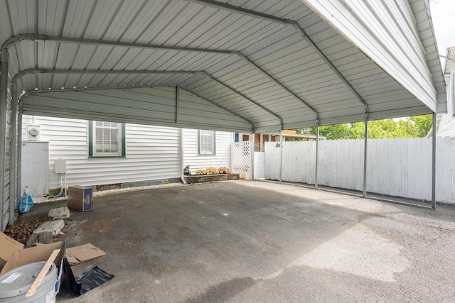 garage featuring fence and a detached carport