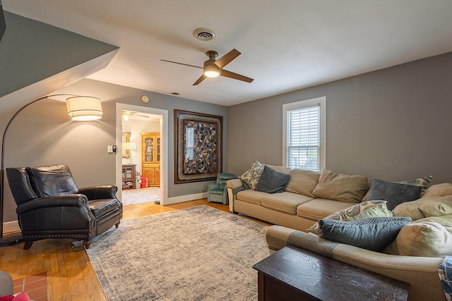 living room featuring a ceiling fan, light wood-type flooring, and baseboards