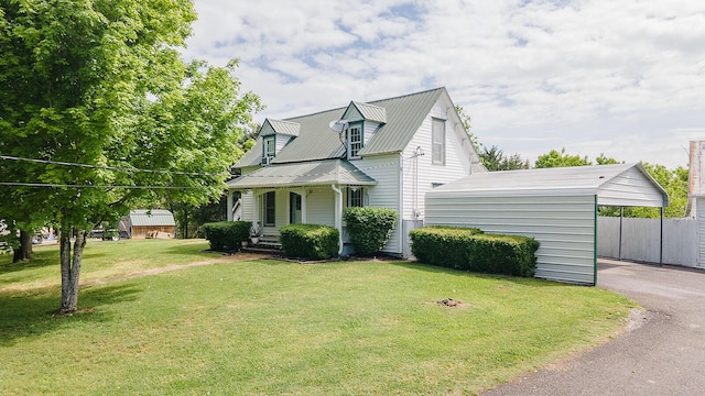cape cod-style house with a carport, a front yard, metal roof, asphalt driveway, and a porch