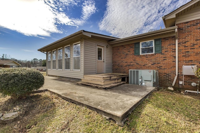 rear view of property with brick siding and central air condition unit