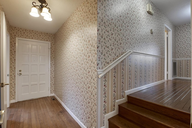 entryway with stairs, wood-type flooring, baseboards, and wallpapered walls