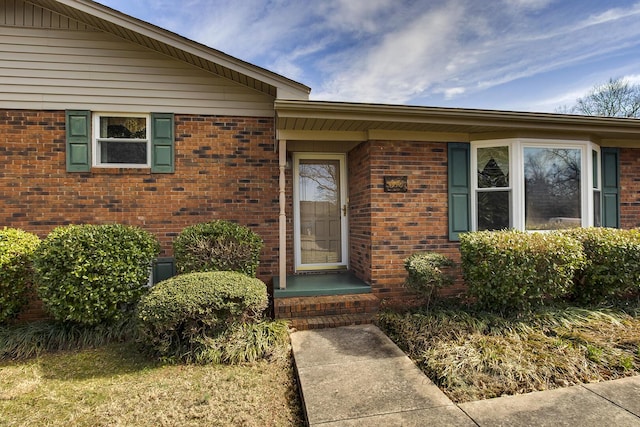 view of exterior entry featuring brick siding