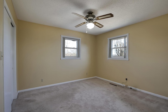 empty room with plenty of natural light, baseboards, and carpet flooring