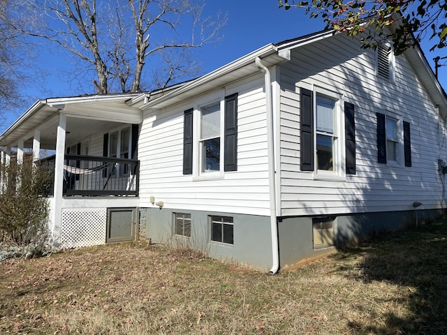 view of home's exterior featuring a balcony and a lawn