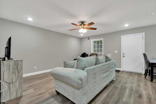 living area featuring ceiling fan, light wood-style floors, recessed lighting, and baseboards