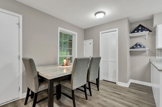 dining room with light wood-type flooring and baseboards