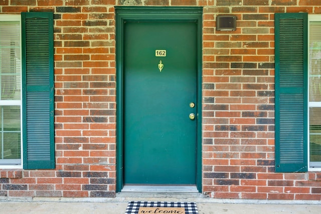 property entrance featuring brick siding
