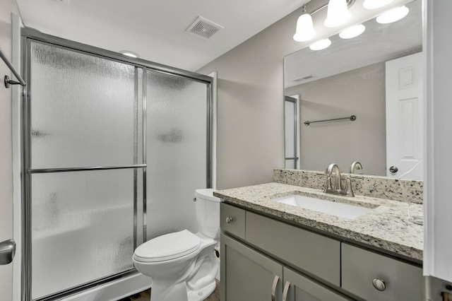 full bathroom featuring a shower stall, toilet, and vanity