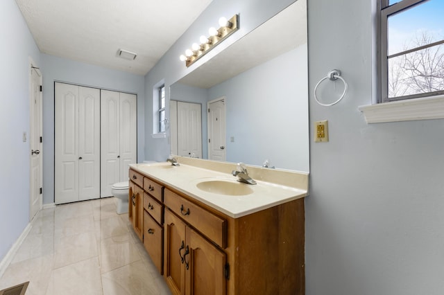 bathroom with vanity, tile patterned flooring, and toilet