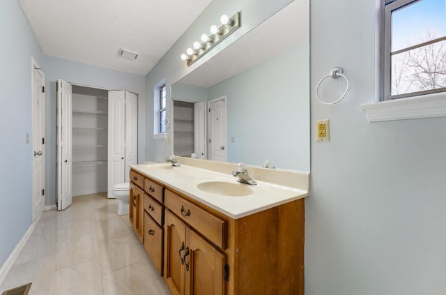 bathroom with vanity, toilet, and tile patterned flooring