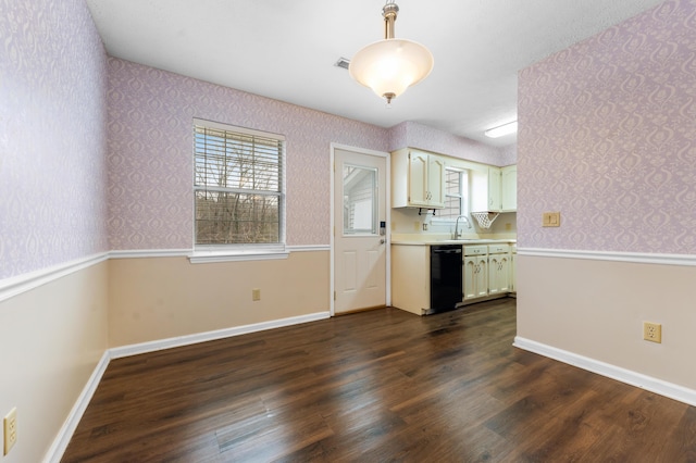 kitchen featuring plenty of natural light, black dishwasher, sink, and dark hardwood / wood-style flooring