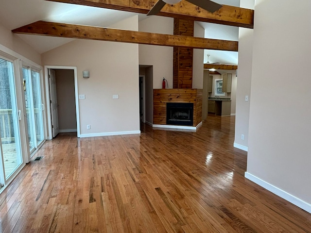 unfurnished living room with ceiling fan, beamed ceiling, high vaulted ceiling, and hardwood / wood-style flooring