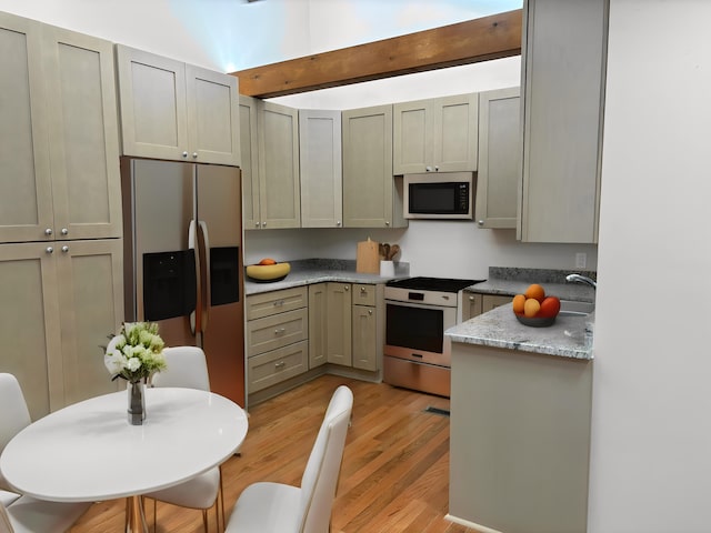 kitchen featuring stainless steel appliances, light hardwood / wood-style flooring, gray cabinetry, and light stone counters