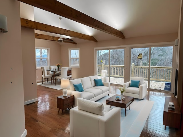 living room featuring vaulted ceiling with beams, ceiling fan, a healthy amount of sunlight, and wood-type flooring