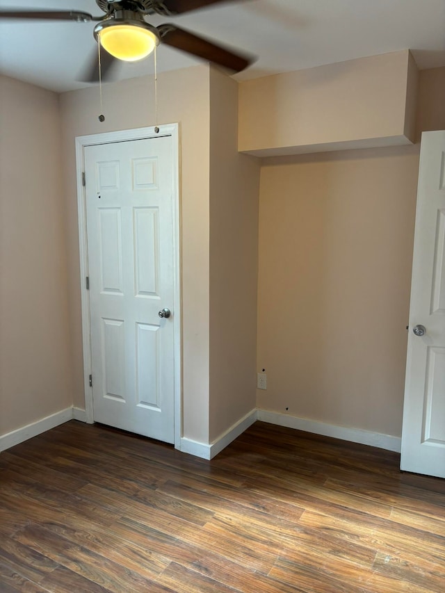 empty room with ceiling fan and dark hardwood / wood-style floors