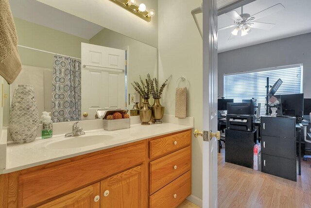 full bath featuring a ceiling fan, a shower with curtain, vanity, and wood finished floors