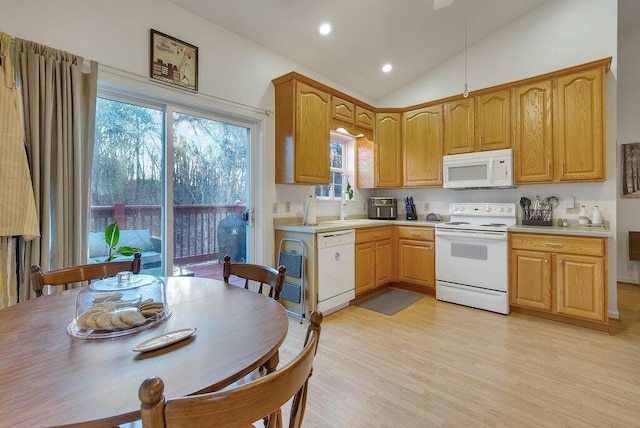 kitchen with vaulted ceiling, white appliances, plenty of natural light, and light wood-style floors