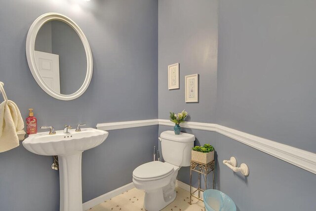 bathroom featuring toilet and baseboards