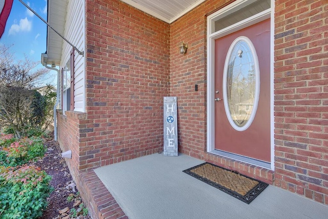 view of exterior entry featuring brick siding