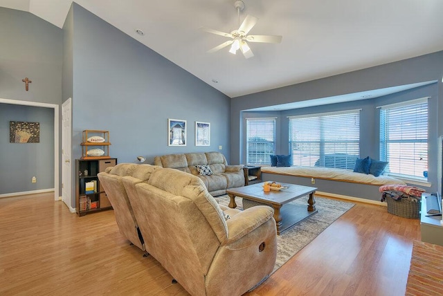 living area featuring ceiling fan, high vaulted ceiling, light wood-type flooring, and baseboards