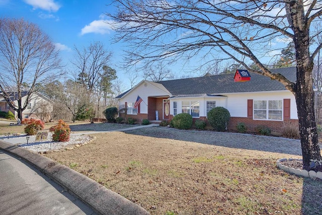 single story home with brick siding and a front yard