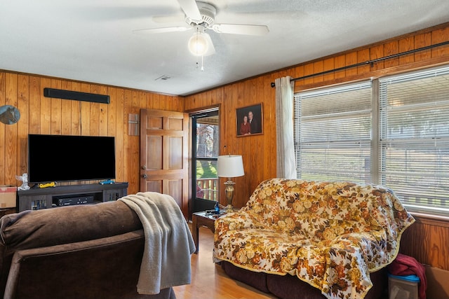 9712 Birchwood Pike, Harrison, TN 37341 - living area with a textured ceiling, wood walls, wood finished floors, and a ceiling fan