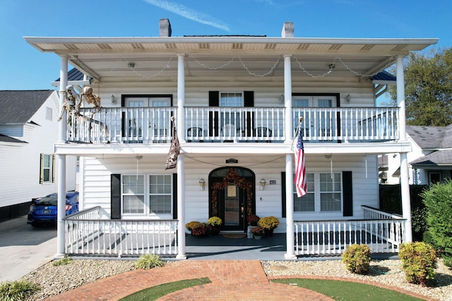 view of front of property with covered porch and a balcony