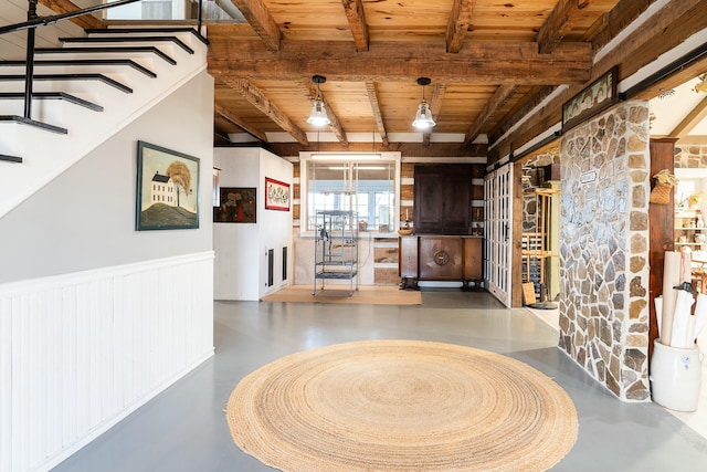 hall with wooden ceiling, beam ceiling, and concrete flooring