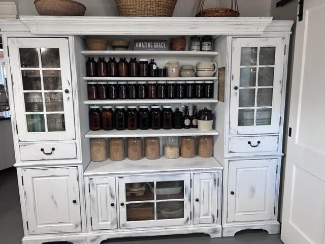 bar featuring a barn door and white cabinets