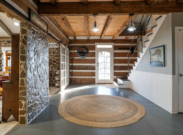 foyer featuring beamed ceiling and a barn door