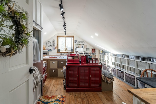 interior space with vaulted ceiling, rail lighting, and light hardwood / wood-style flooring