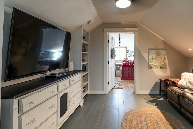 living room with dark wood-type flooring, a textured ceiling, and vaulted ceiling